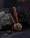 A hand presents a wooden kuripe pipe, meticulously handcrafted for hape snuff application This unique smoking accessory, with its necklace design and rustic charm, exemplifies traditional shamanic tools and doubles as a protective herbal medicine kit