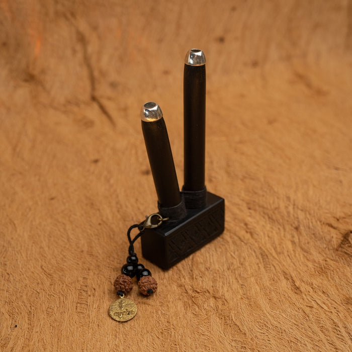 A person holds an elite rosewood kuripe pipe, detailed with geometric patterns for hape snuff application, doubling as a necklace, representing unique shamanic tools