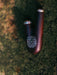 Wooden pipe with metallic accents on a textured green surface