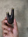 Hand holding a wooden object with gold tips against a neutral background