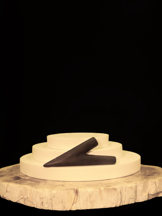 Decorative item with a black 'Z' on a wooden base against a black background