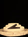Decorative item with a black 'Z' on a wooden base against a black background