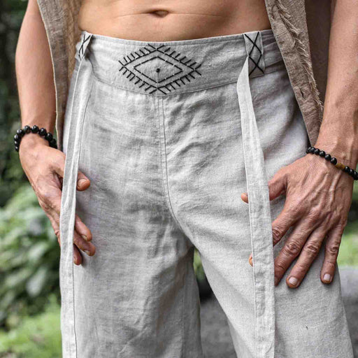 Close-up of unisex linen pants featuring a hand-embroidered tribal pattern, embodying Boho and shamanic styles