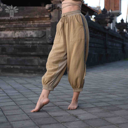 Close-up of cotton pants featuring a white hand-embroidered tribal pattern, embodying Boho and shamanic styles