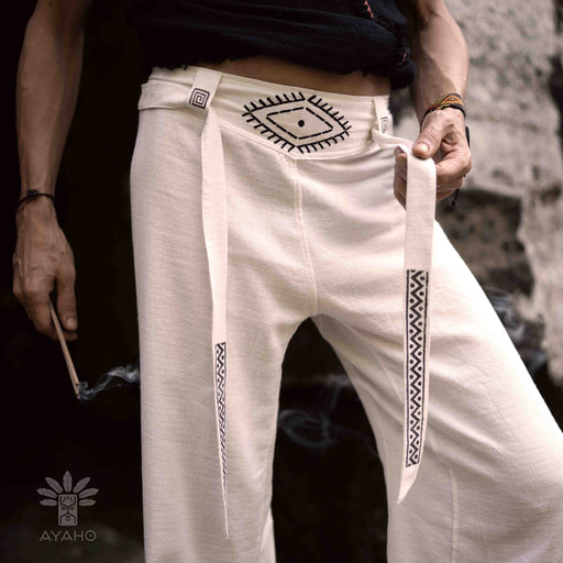 Close-up of unisex linen pants featuring a white hand-embroidered tribal pattern, embodying Boho and shamanic styles