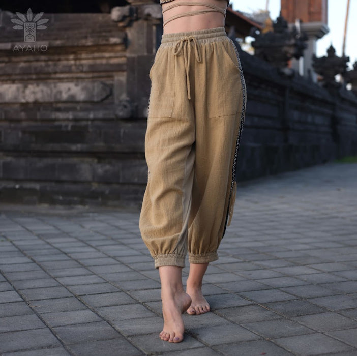 Close-up of cotton pants featuring a white hand-embroidered tribal pattern, embodying Boho and shamanic styles