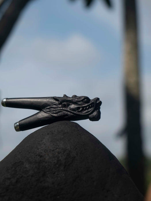 Black decorative object on a rock with a blurred natural background