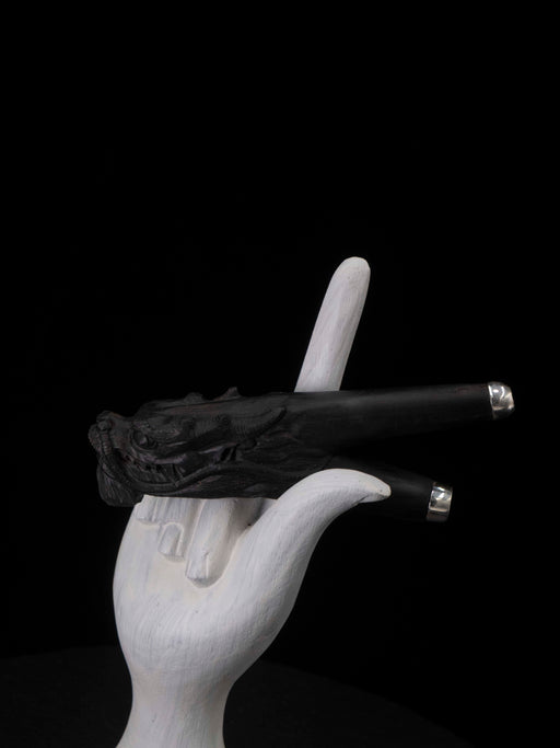 White hand holding a black gun against a black background