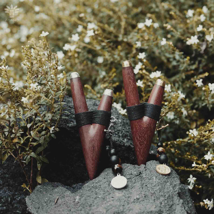 A serene woman holds a high-quality wooden kuripe blowpipe, used as a hape snuff applicator. The kuripe, doubling as a necklace with detailed charms, represents both a shamanic tool and a unique gift.