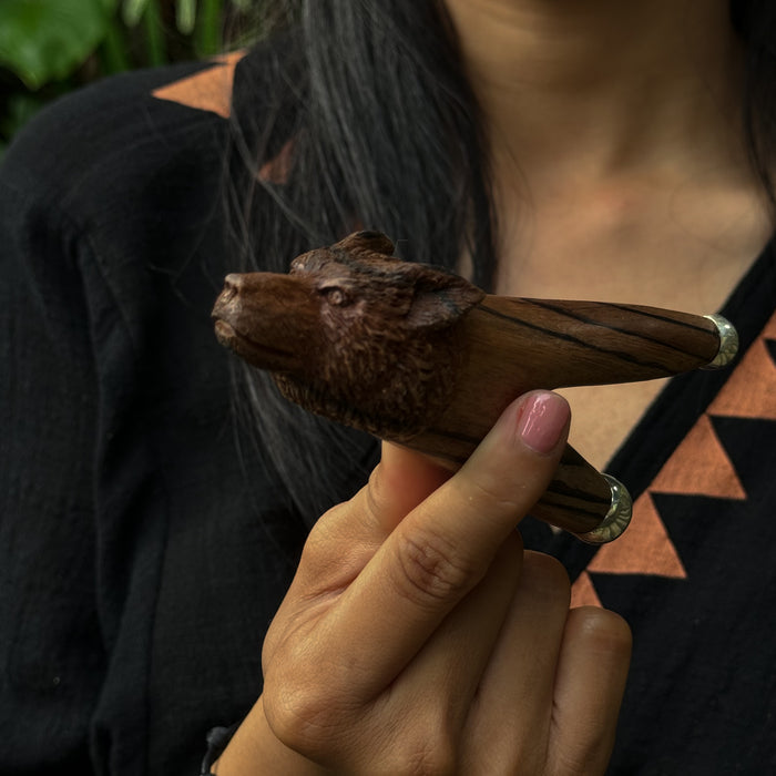 Wooden bat figurine held by a person with a blurred background