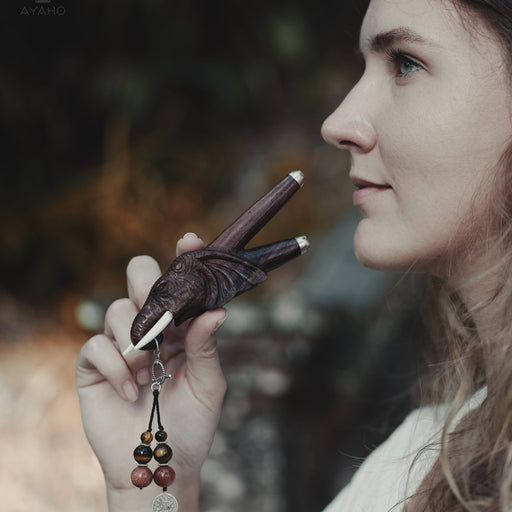 a wooden kuripe elephant pipe, designed for hape snuff application. The kuripe, linked to a charm-adorned necklace, serves as a unique, handmade smoking accessory and part of a shamanic protection kit, blending herbal medicine traditions