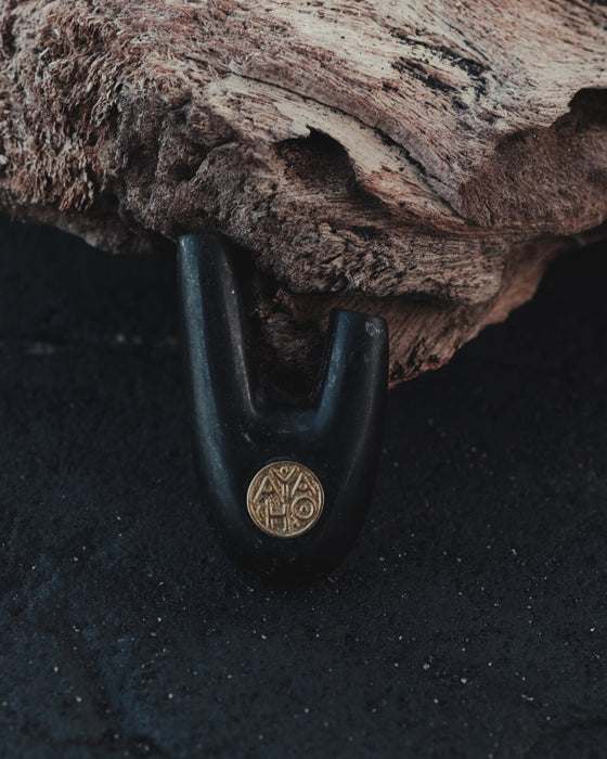 Bronze logo on Kuripe made from volcanic stone, adding sophistication.