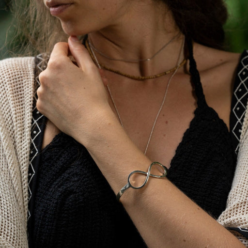 Sleek sterling silver bracelet featuring an infinity symbol, meticulously handcrafted to promote energy flow and serve as a protective talisman