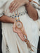 Dream catcher pendant featuring crescent moon charms and silver-toned beads, draped over a vintage journal.