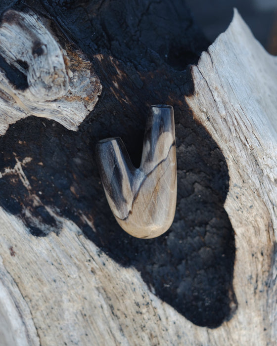 Distinctive character of the Kuripe pipe crafted from petrified wood, unique to each piece.