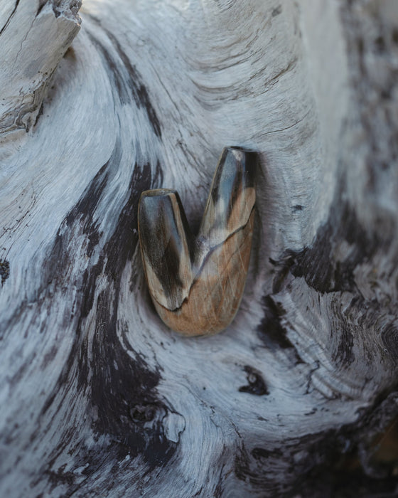Earthy aesthetic of the Kuripe pipe crafted from petrified wood, blending with nature.