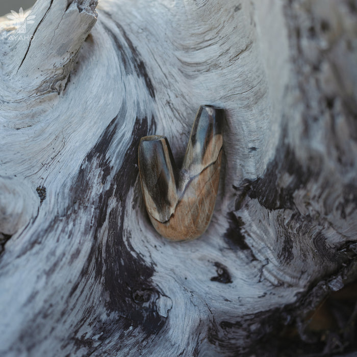 Earthy aesthetic of the Kuripe pipe crafted from petrified wood, blending with nature.