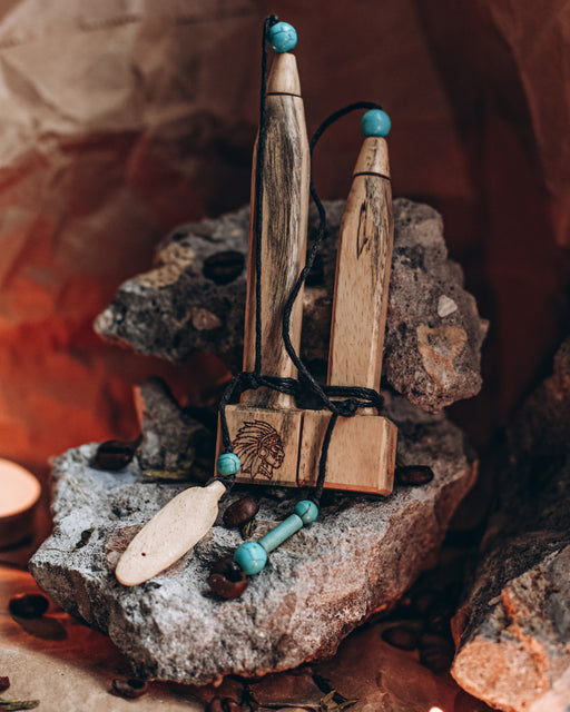 Hand-carved tamarind wood pipe with traditional Shipibo patterns and turquoise inlay, resting on ceremonial cloth