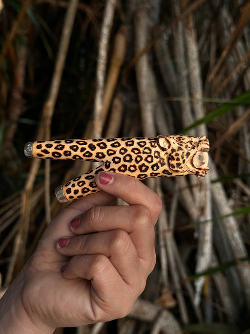 Shamanic jaguar totem on a kuripe smoking pipe, handcrafted for Hape rituals.