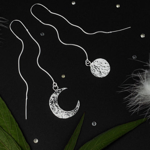 Charming mismatched silver earrings depicting the sun and moon, crafted as aesthetic shamanic tools and serving as a unique talisman for celestial harmony.