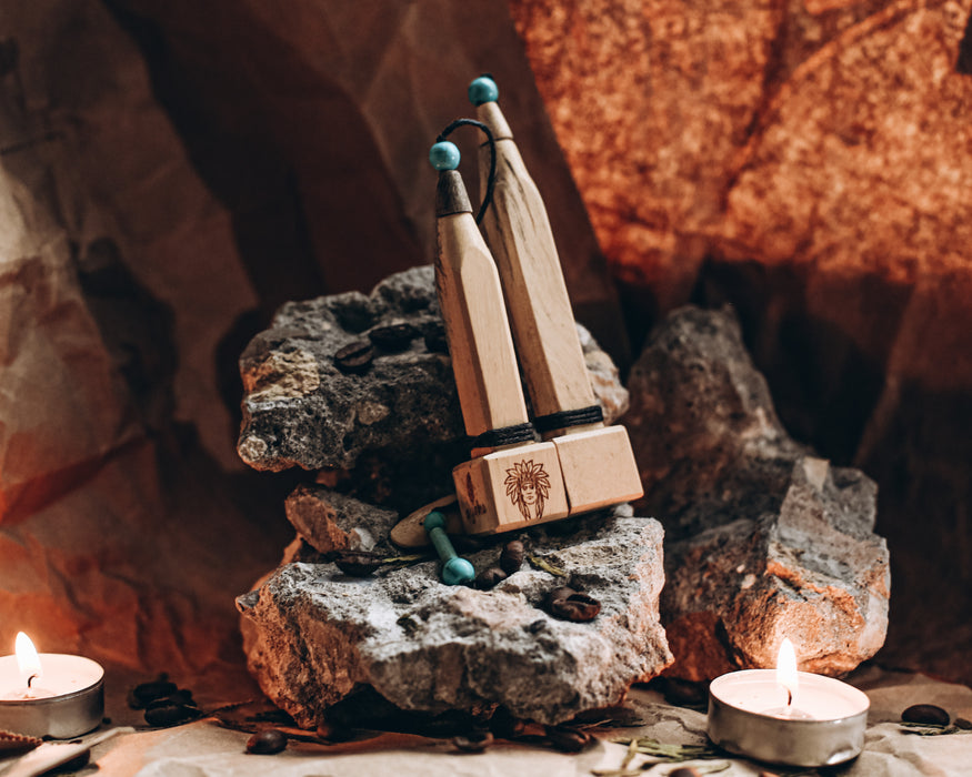 Complete shamanic toolset featuring wooden feather carving and healing crystals on dark wooden background