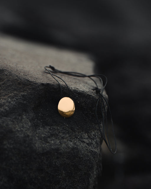 Small copper mirror pendant on an adjustable cord, tucked into a suede pouch for on-the-go spiritual practice.