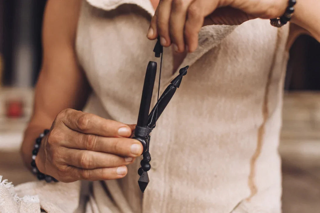 Person holding a black bow with a blurred background