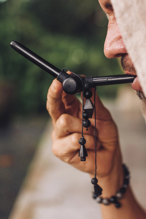 Close-up of a person holding a bow with a blurred natural background