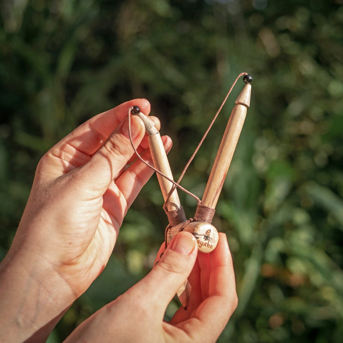 Hand holding a slingshot with a blurred green background