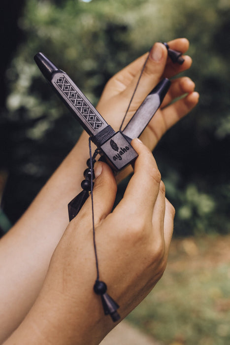 Hand holding a decorative knife with a blurred natural background