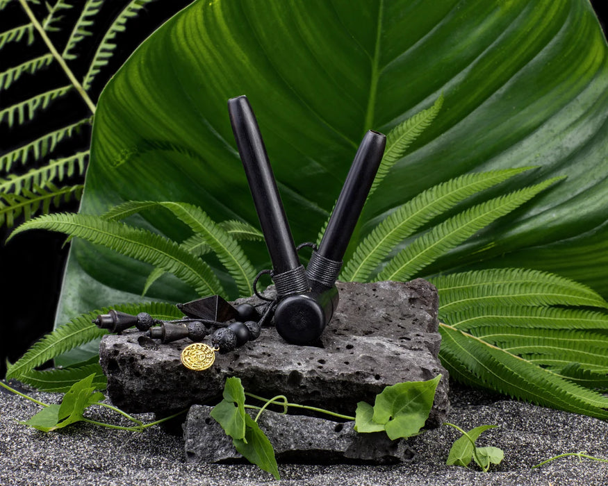 Black decorative item on a rock with green leaves in the background