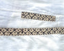 Decorative ribbon with black pattern on a white fabric background