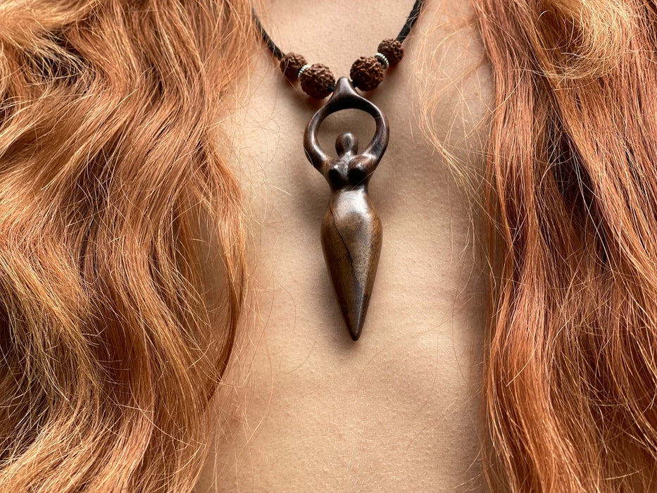 Necklace with a unique pendant worn by a person with red hair