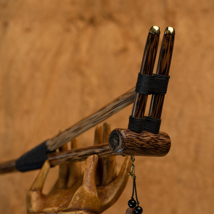Wooden archery bow with three arrows on a wooden background