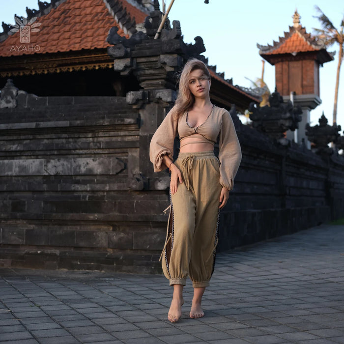 Woman in a beige outfit standing in front of traditional architecture