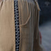 Close-up of a beige garment with a black and white patterned trim, featuring the AYANO brand logo.