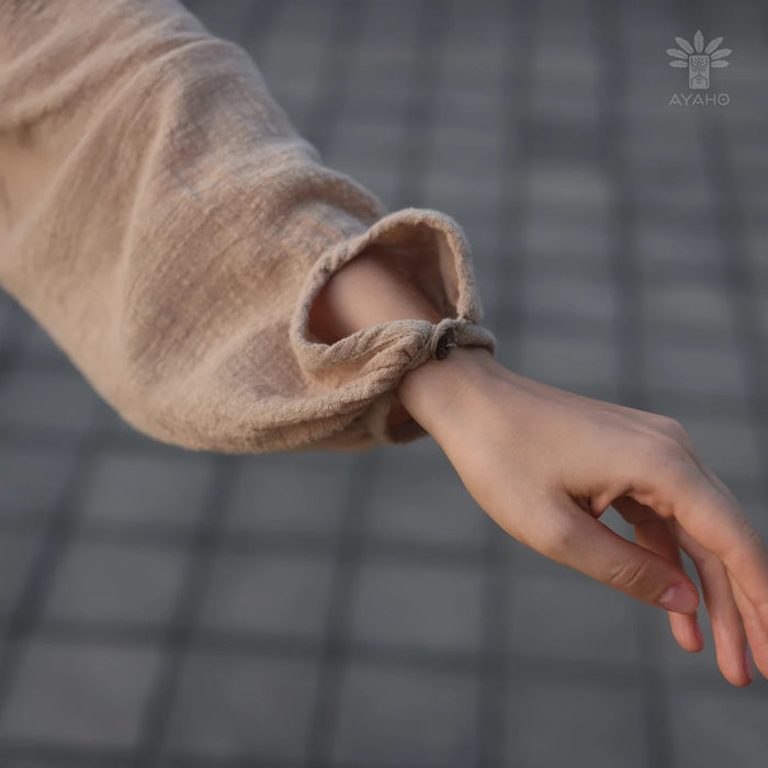 Close-up of a person wearing a beige textured sleeve with a blurred background