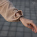 Close-up of a person wearing a beige textured sleeve with a blurred background