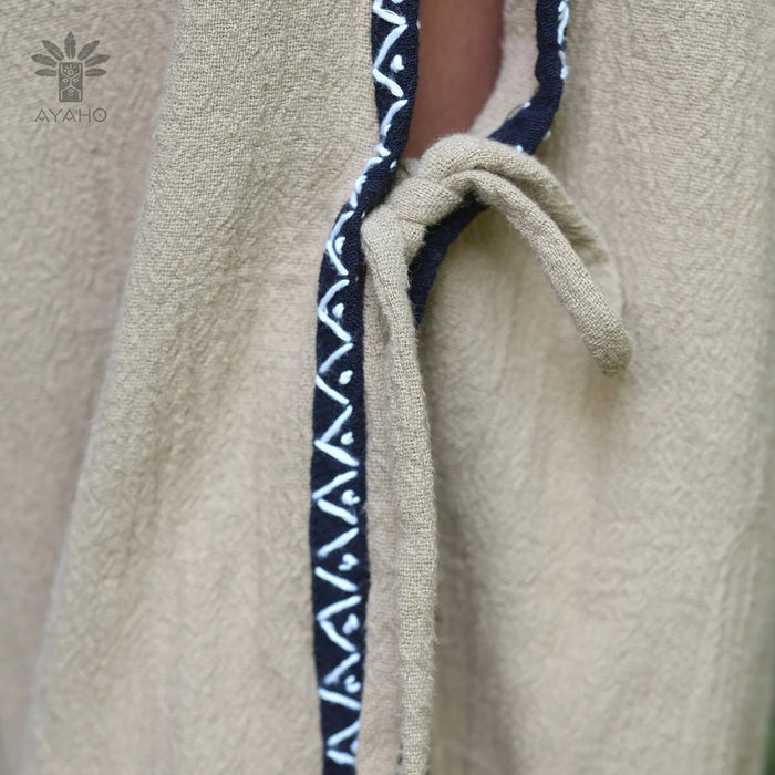 Close-up of a beige fabric with navy blue embroidered trim, featuring the Ayahob brand logo.
