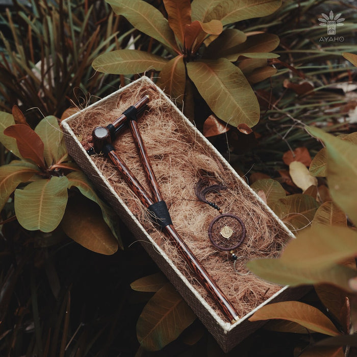 Set of wooden tools in a natural box with plants in the background