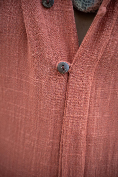 Close-up of a textured pink garment with buttons