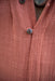 Close-up of a textured pink garment with buttons
