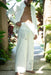 Man wearing a white embroidered outfit in a tropical setting