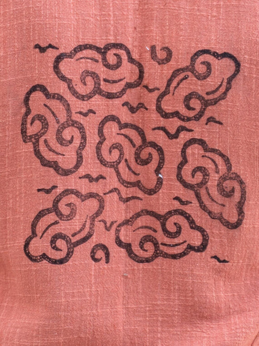 Decorative cloud pattern on a textured pink fabric background