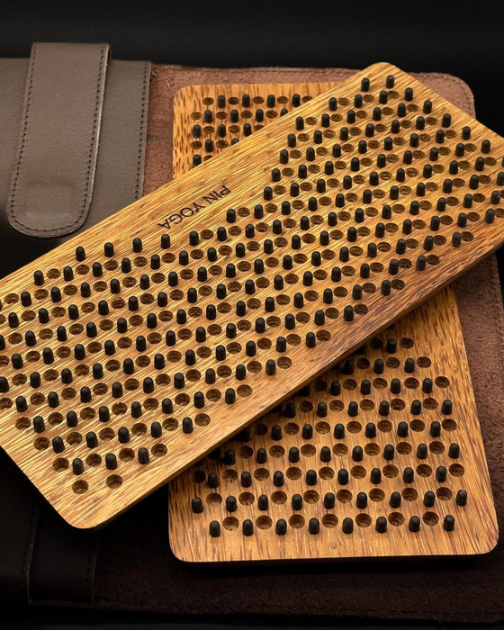 Two wooden brush scrubbers with textured surface on a dark background