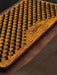 Wooden massage board with textured surface and 'PIN YOGA' branding on a brown mat.