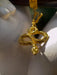 Gold snake-shaped pendant on a white surface