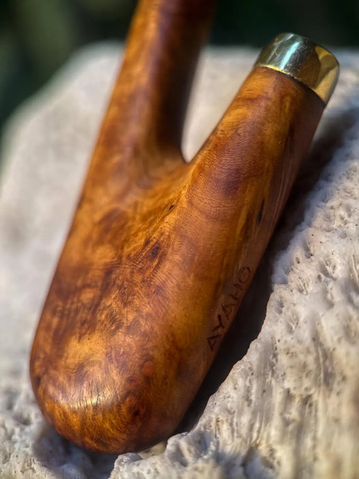 Wooden handle with brass fitting on a stone surface