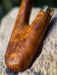 Wooden handle with brass fitting on a stone surface
