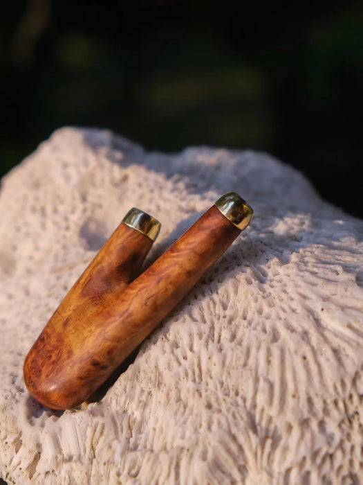 Wooden tool with gold accents on a textured surface